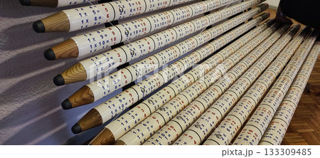 A park bench made of wooden posts painted to resemble large pencils, with a multiplication table printed on each. Concept for modern park design, school education, and leisure. A park bench made of wooden posts painted to resemble large pencils, with a multiplication table printed on each. Concept for modern park design, school education, and leisure. 133309485