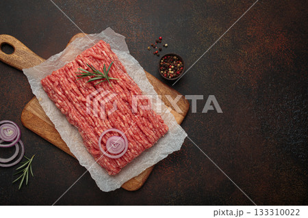 Raw ground minced meat chopping wooden board ingredients rosemary onion cooking copy space 133310022