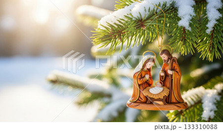 Nativity scene ornament of Holy Family hanging on a snowy Christmas tree branch. 133310088