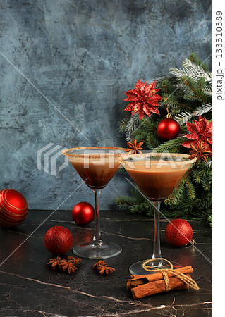 Christmas martini with cinnamon, nutmeg, and dark chocolate against a backdrop of fir branches, Christmas and holiday concept. A warming milk drink during the cold season, Christmas Eve concept 133310389