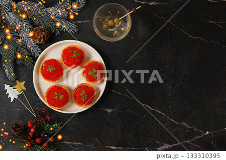 Christmas and New Year's dishes, a canap set for the festive table. A plate of p t tartlets and red caviar on a concrete table with a glass of wine and olives, Christmas Eve concept, restaurant menu Christmas and New Year's dishes, a canap set for the festive table. A plate of p t tartlets and red caviar on a concrete table with a glass of wine and olives, Christmas Eve concept, restaurant menu 133310395