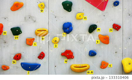 カラフルなホールドが配置された屋内クライミングウォール 133310406