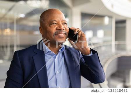 Closeup of mature African American businessman talking on cellphone with confident smile 133310451