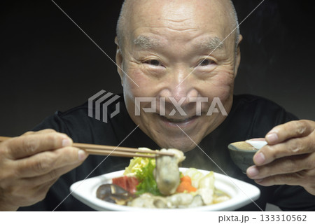 温かい牡蠣鍋を笑顔で食べる老人 温かい牡蠣鍋を笑顔で食べる老人 133310562