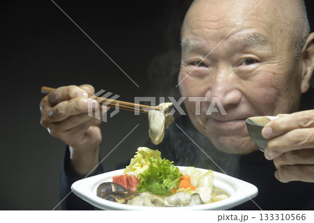 温かい牡蠣鍋を笑顔で食べる老人 温かい牡蠣鍋を笑顔で食べる老人 133310566