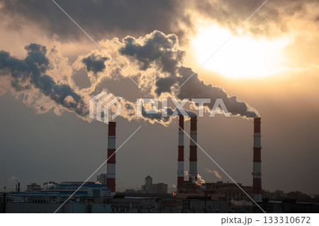 Smoke from factory pipe of heat station in city in winter. Fuel oil or natural gas-fired power plant 133310672