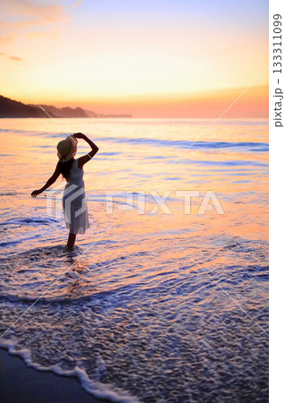 海に沈む夕日と女性のシルエット 海に沈む夕日と女性のシルエット 133311099