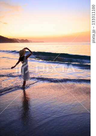 海に沈む夕日と女性のシルエット 海に沈む夕日と女性のシルエット 133311100
