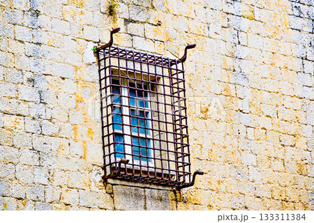 Window with iron bars on stone eall 133311384