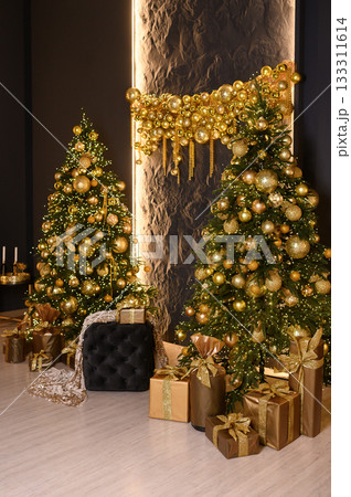 Luxurious Christmas interior with two beautifully decorated Christmas trees adorned with golden ornaments and lights. Elegant wrapped gifts with golden ribbons sit beneath the trees, creating a 133311614