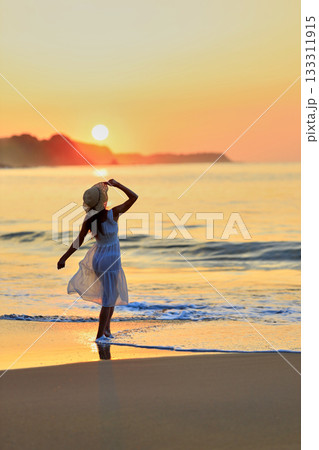 夕日の海を見つめる彼女 133311915