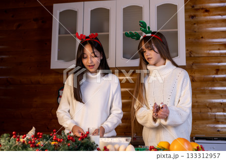 The two women are preparing Christmas treats in the kitchen 133312957
