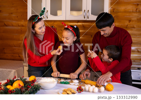 A family is baking Christmas cookies together in the kitchen 133312990