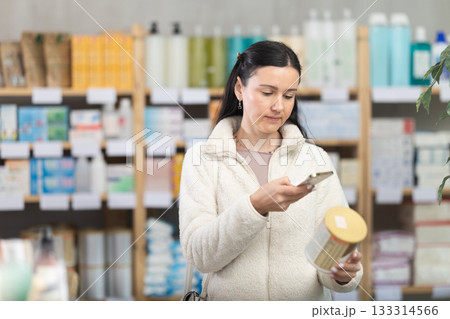 Woman scans barcode of jar of baby food Woman scans barcode of jar of baby food 133314566