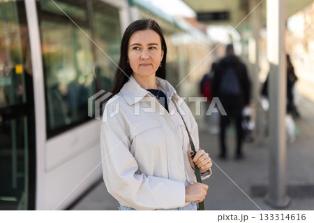 Woman traveler wait tram at transport stop station. Woman traveler wait tram at transport stop station. 133314616