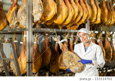 Girl checks quality of spanish jamon in workshop 133314701