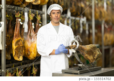 man presents jamon on a stand 133314702
