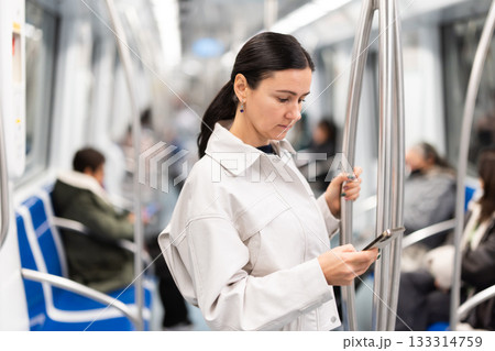 Woman using smartphone while traveling in subway car 133314759