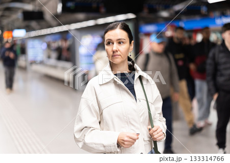 Girl is standing on metro platform station, waiting for transport to arrive 133314766