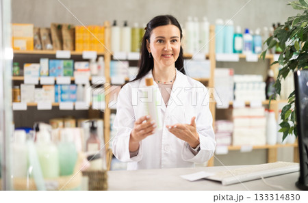 Middle-aged female pharmacist offering shampoo Middle-aged female pharmacist offering shampoo 133314830