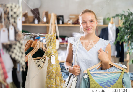 Teenage girl choosing summer clothes in store 133314843