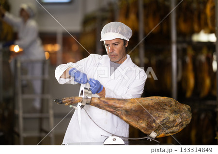 Man preparing to slice jamon on a stand 133314849