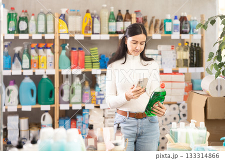 Woman scanning dishwashing detergent barcode on mobile Woman scanning dishwashing detergent barcode on mobile 133314866