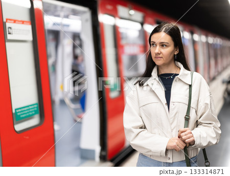 Female passenger awaits the metro train at arrival station Female passenger awaits the metro train at arrival station 133314871