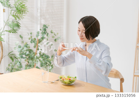 スマホでサラダの写真を撮る女性 スマホでサラダの写真を撮る女性 133315056