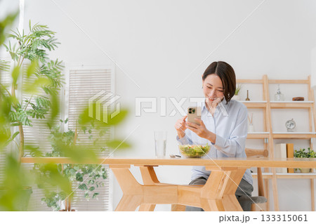 スマホでサラダの写真を撮る女性 133315061