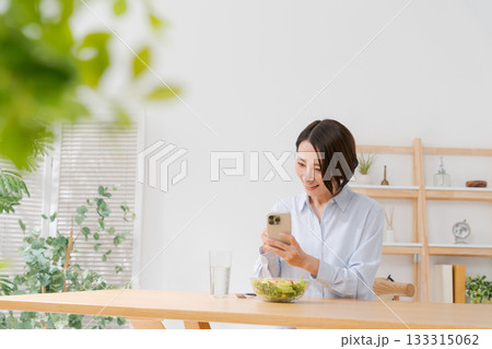 スマホでサラダの写真を撮る女性 133315062