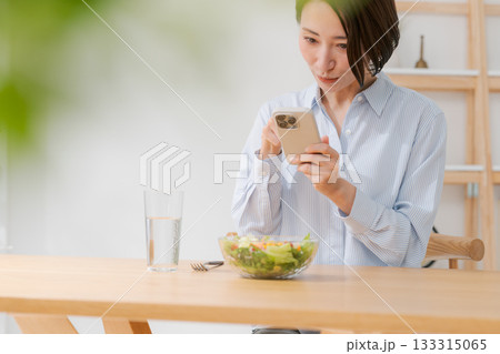 スマホでサラダの写真を撮る女性 スマホでサラダの写真を撮る女性 133315065