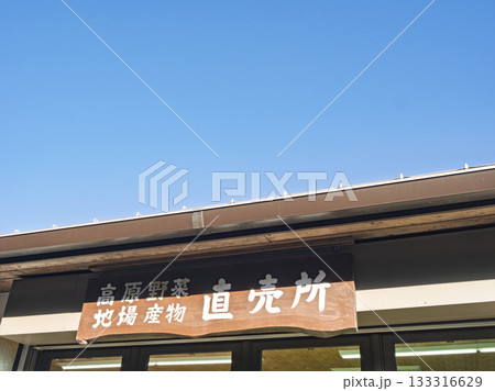 青空に映える地場産物直売所の看板 133316629