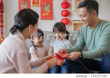 中国のお正月文化　旧正月に赤い封筒を子どもに渡す家族 ― 笑顔あふれる祝祭の室内 133317163