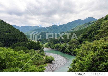 大井川に架かる吊り橋と緑の山々の風景 大井川に架かる吊り橋と緑の山々の風景 133317336