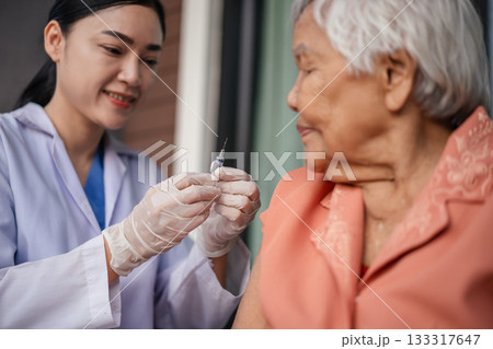 doctor holding syringe and making injection vaccine to senior woman doctor holding syringe and making injection vaccine to senior woman 133317647