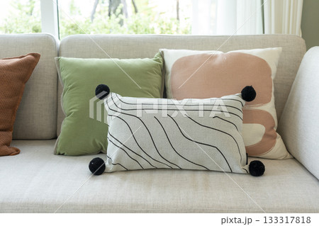 Close up of modern abstract pillow with doodle face pattern on comfortable sofa. 133317818