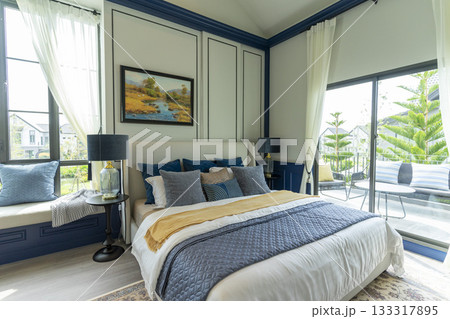 Interior of modern spacious master bedroom with big bed under a wall decoration and brown carpet. Interior of modern spacious master bedroom with big bed under a wall decoration and brown carpet. 133317895