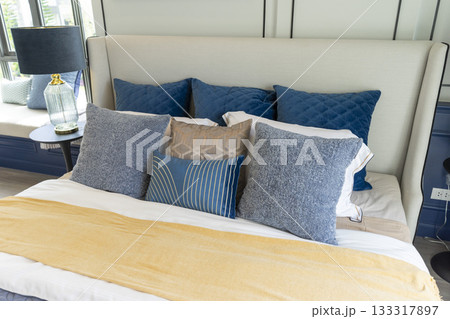 Interior of modern spacious master bedroom with big bed under a wall decoration and brown carpet. Interior of modern spacious master bedroom with big bed under a wall decoration and brown carpet. 133317897