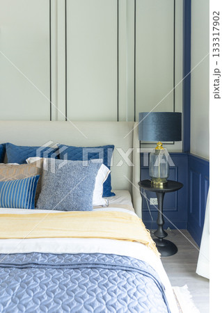 Interior of modern spacious master bedroom with big bed under a wall decoration and brown carpet. 133317902