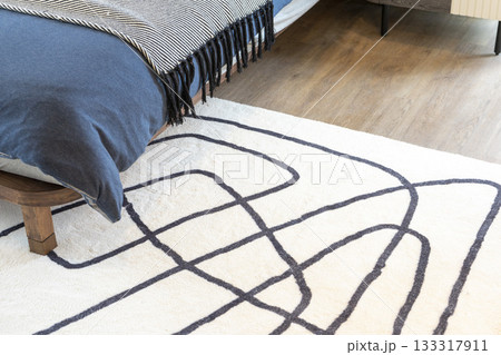 Stylish composition of modern bedroom interior with carpet on the floor.  133317911