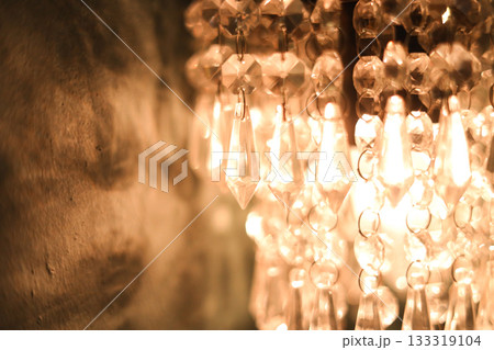 Close-up of a Vintage Chandelier Glowing Under Warm Incandescent Lights Close-up of a Vintage Chandelier Glowing Under Warm Incandescent Lights 133319104