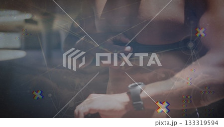 Tugging shorts strap, shirtless fitness athlete wearing fitness watch at gym, with digital overlay Tugging shorts strap, shirtless fitness athlete wearing fitness watch at gym, with digital overlay 133319594