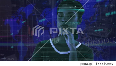 IT specialist standing in data center, resting hand under chin, viewing world map projection 133319665