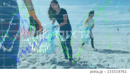 Cleaning group wearing gloves picking up litter on sandy shore, with financial graphs overlay 133319761