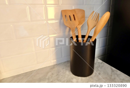Wooden Kitchen Utensils in Black Canister on Marble Countertop Wooden Kitchen Utensils in Black Canister on Marble Countertop 133320890