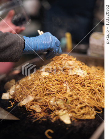 屋台の鉄板で焼きそばを作っているシーン 133320952