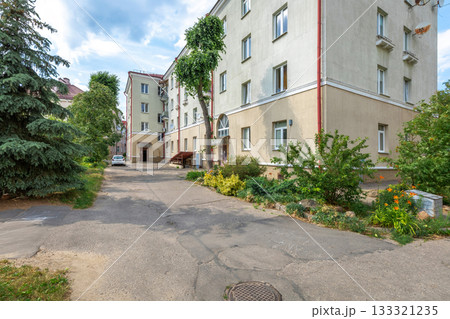 Residential Courtyard with Apartment Building and Green Plants 133321235
