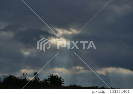 Sun rays through dark clouds in Thailand 133321401