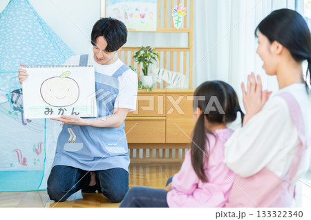 紙芝居をする保育士さん 133322340